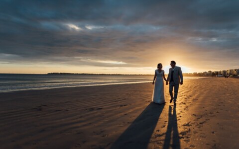 couple marchands sur la plage au couché du soleil