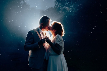 couple qui s'embrasse sous la pluie avec une lumiere forte derriere eux