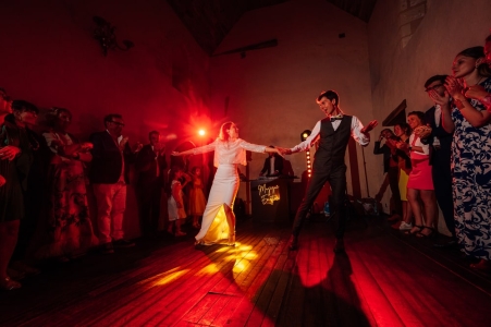 premiere danse des mariés sur une piste de danse avec des flashes rouges derriere eux