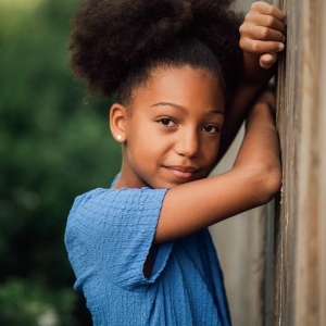 Portrait d'un fille de 10 ans en extérieur contre une palissade