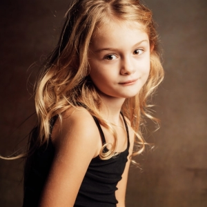 Portrait jeune enfant blonde sur fond sombre =